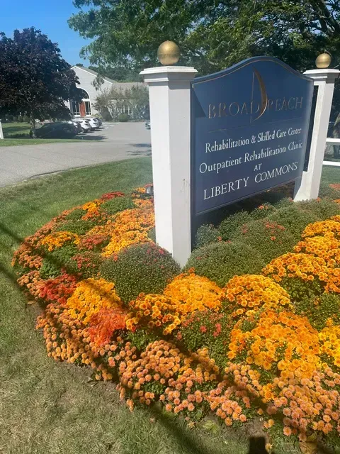 Colorful flower bed beside BroadReach Liberty Commons sign.