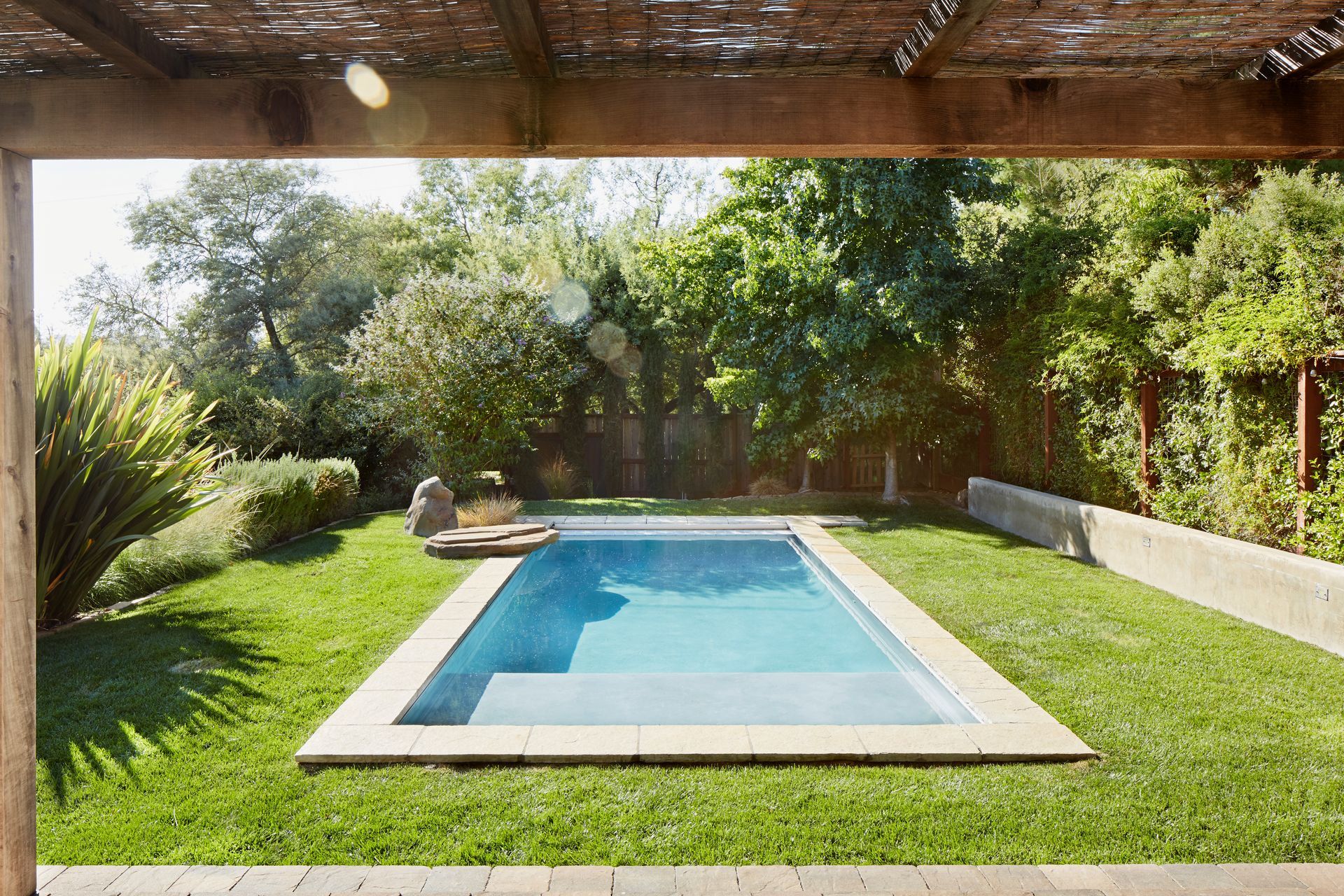 Small pool in a backyard, showcasing pool fence compliance. Small pool in a backyard, showcasing pool fence compliance.