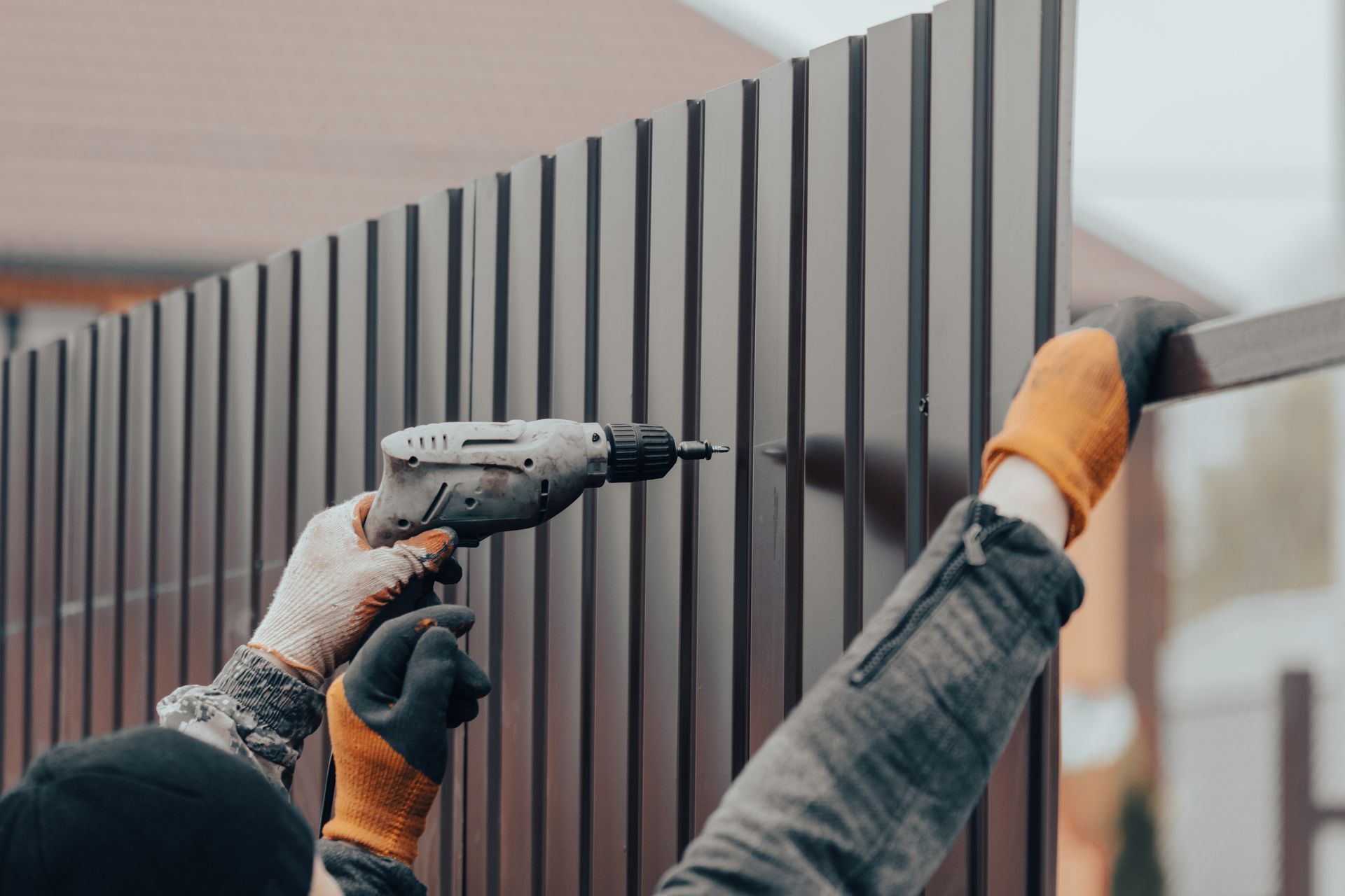 A safety fence being inspected by a worker with green foliage behind him. A safety fence being inspected by a worker with green foliage behind him.