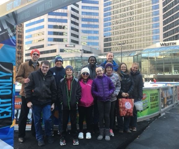 A group of people standing in front of a sign that says