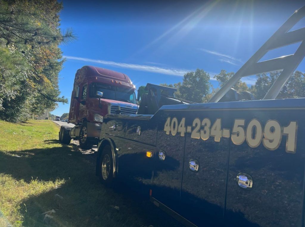 A tow truck is towing a semi truck in a field.