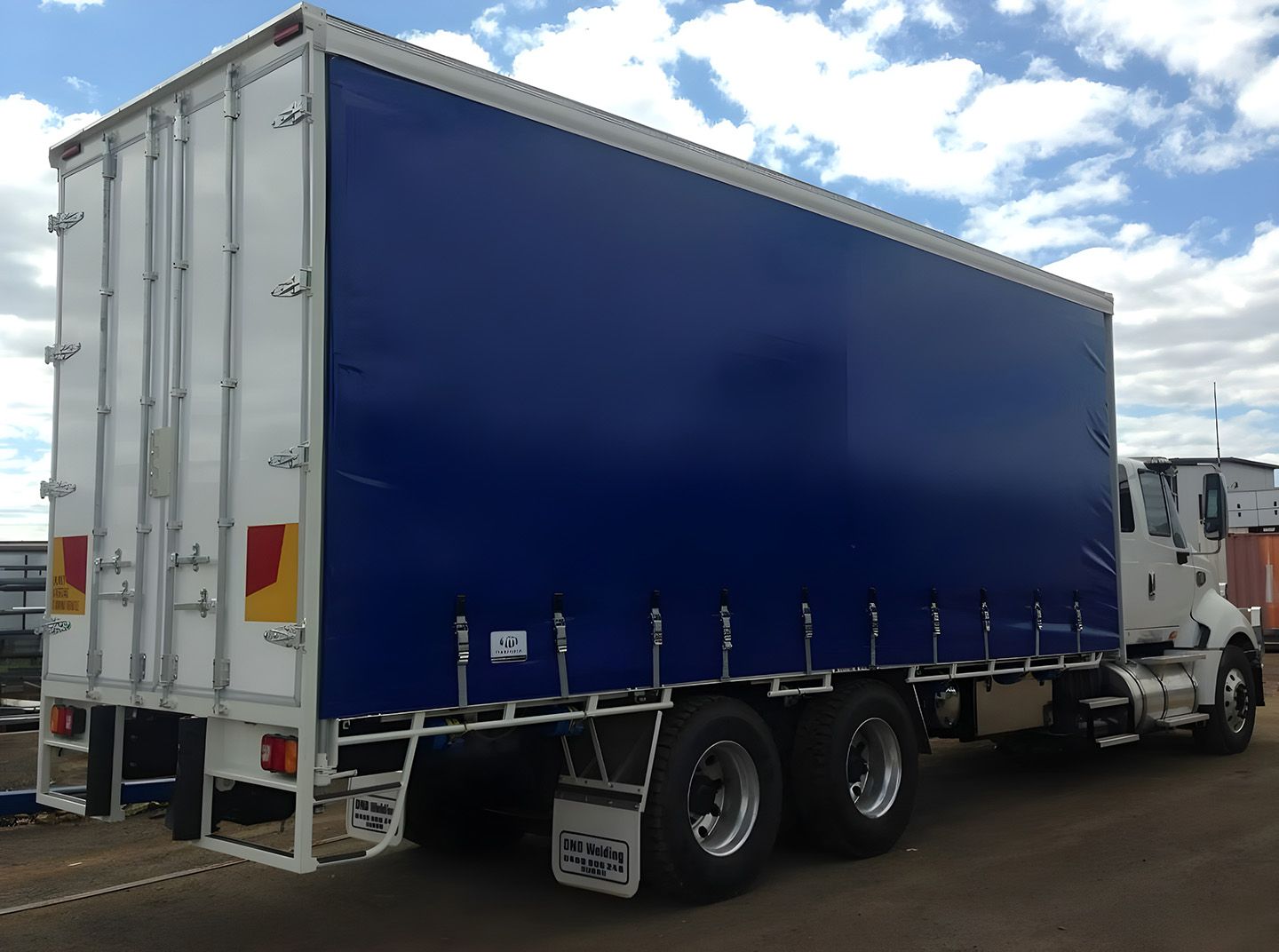 Blue Curtain-Side Trailer Truck Parked Outdoors 