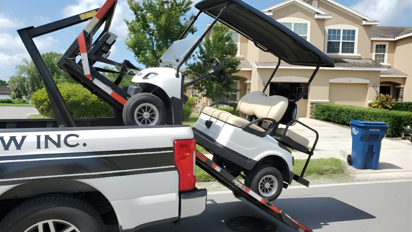 Golf cart being loaded onto a tow truck with a lift, parked in front of a house.