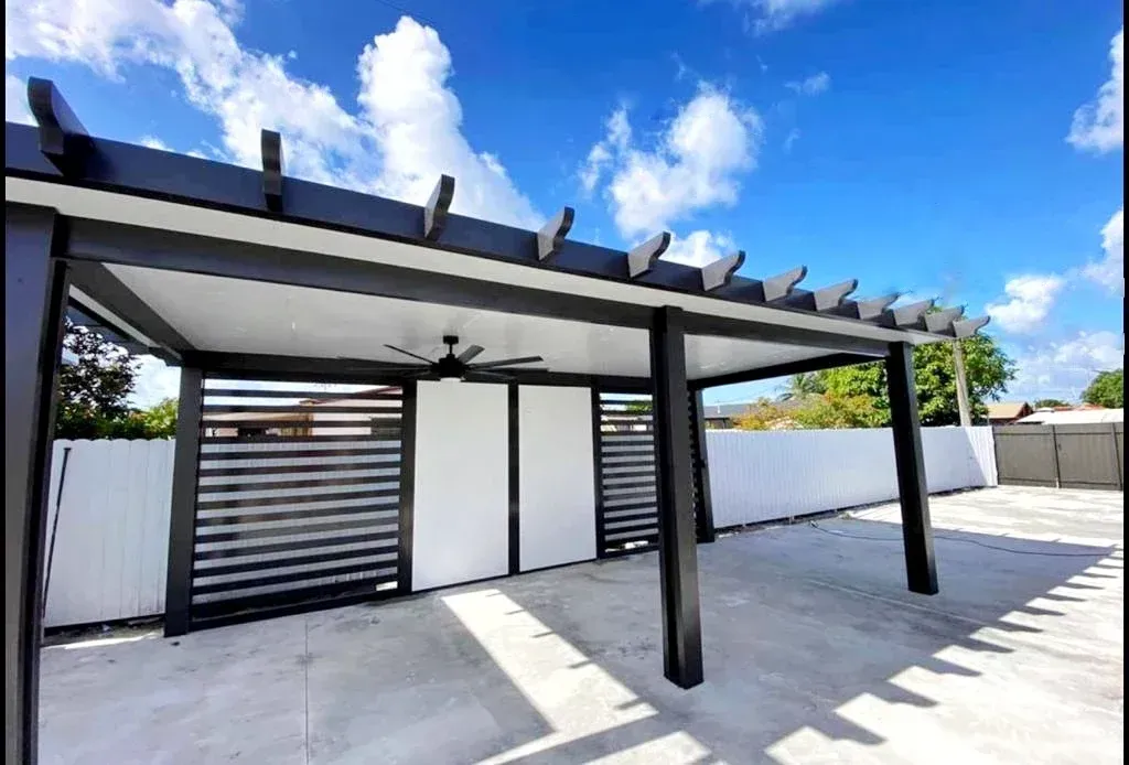 Screened patio with black frames, open doors, and a person using a blower. Outdoors, daytime.