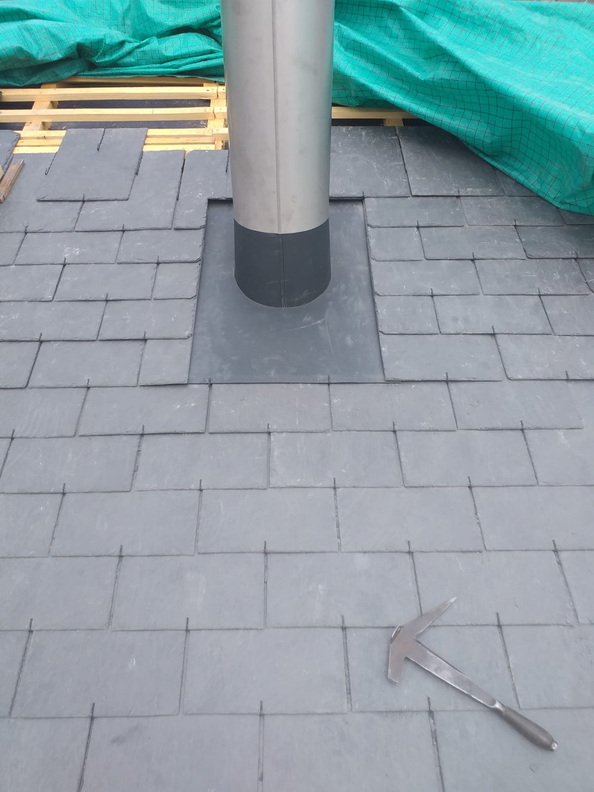 Une cheminée est en cours d'installation sur un toit en briques