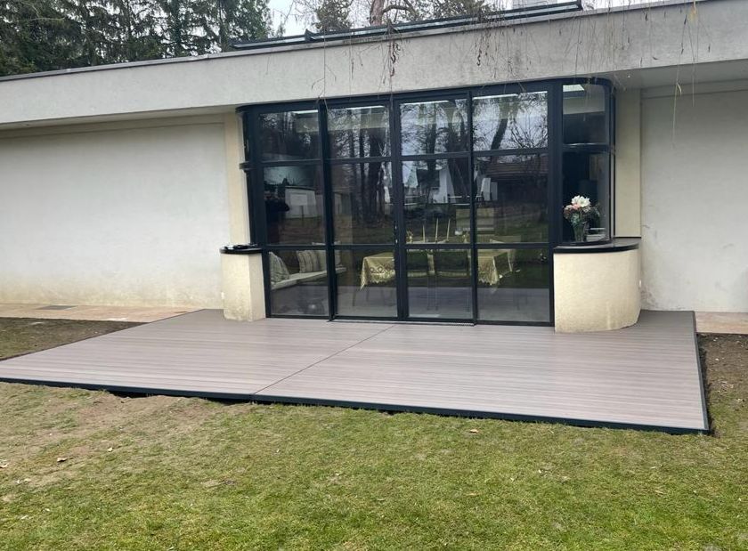 Une grande maison avec un patio devant.