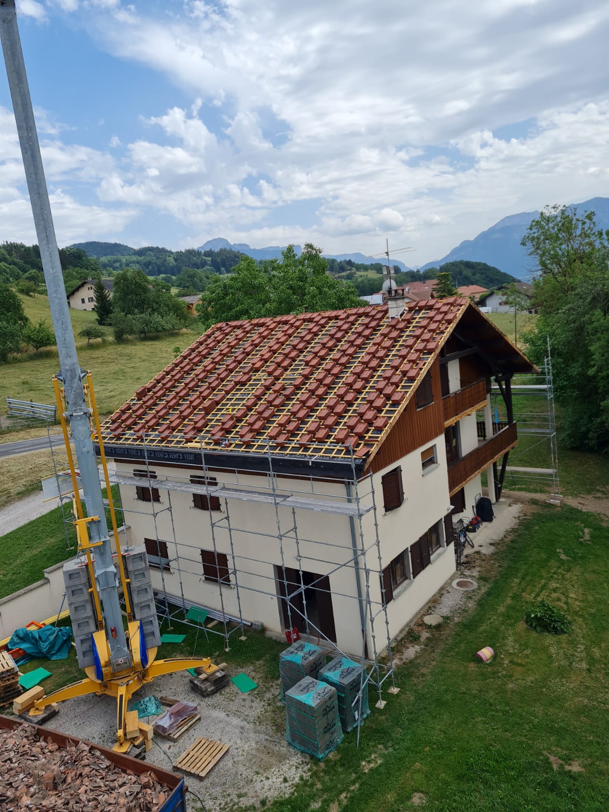 Une vue aérienne d'une maison en construction avec une grue devant.