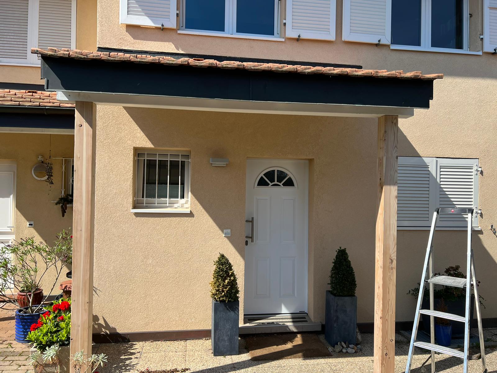 Une maison avec une porte blanche et une échelle devant