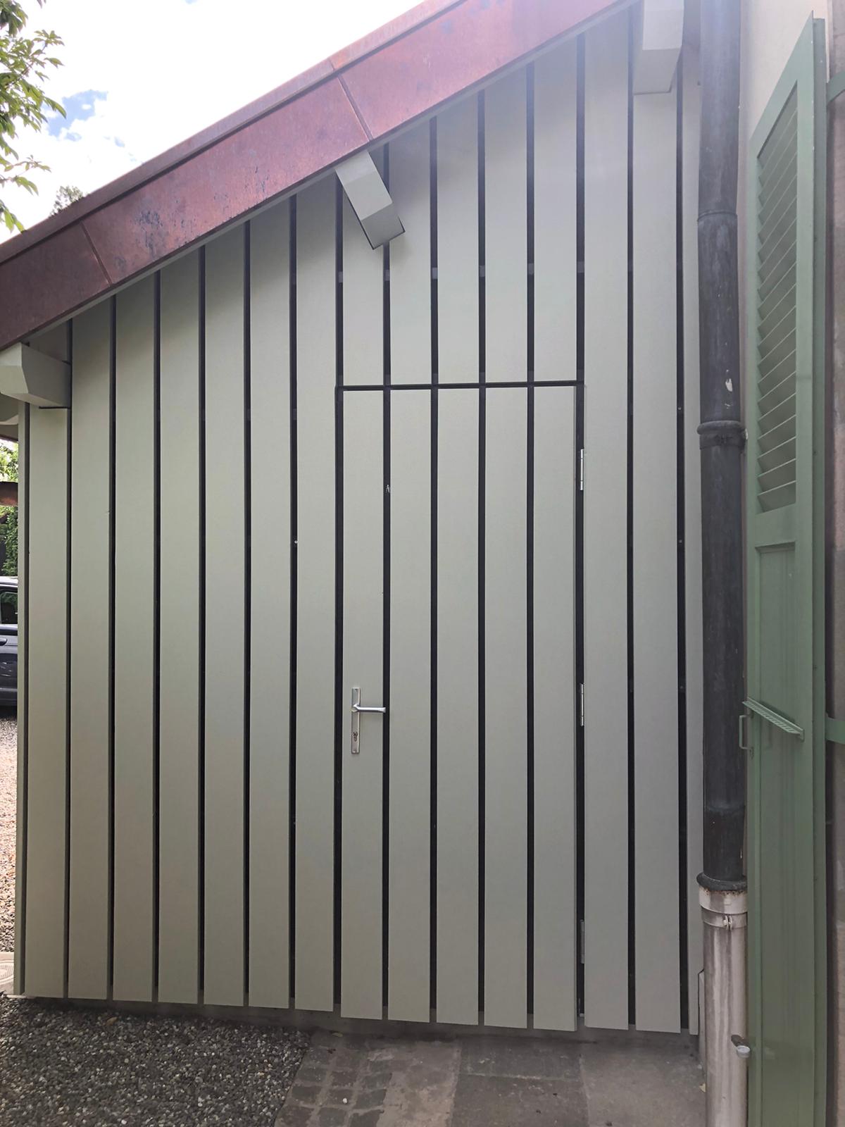 Un hangar avec une porte et des volets sur le côté.
