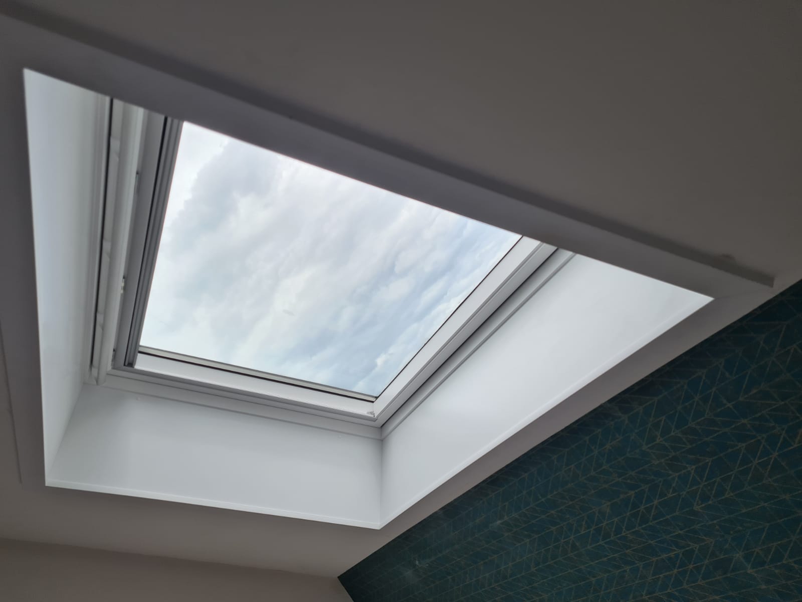 Une lucarne dans une pièce avec un mur bleu