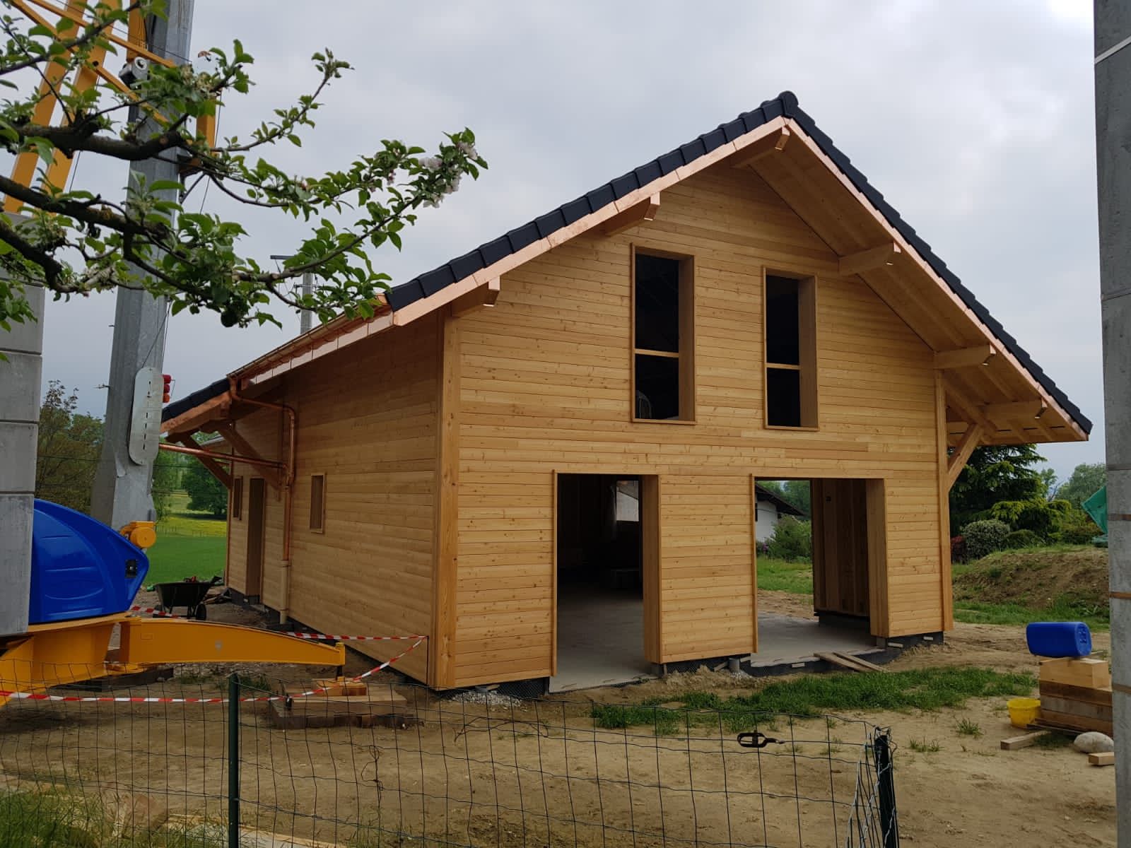 Une maison en bois est en construction avec une grue en arrière-plan