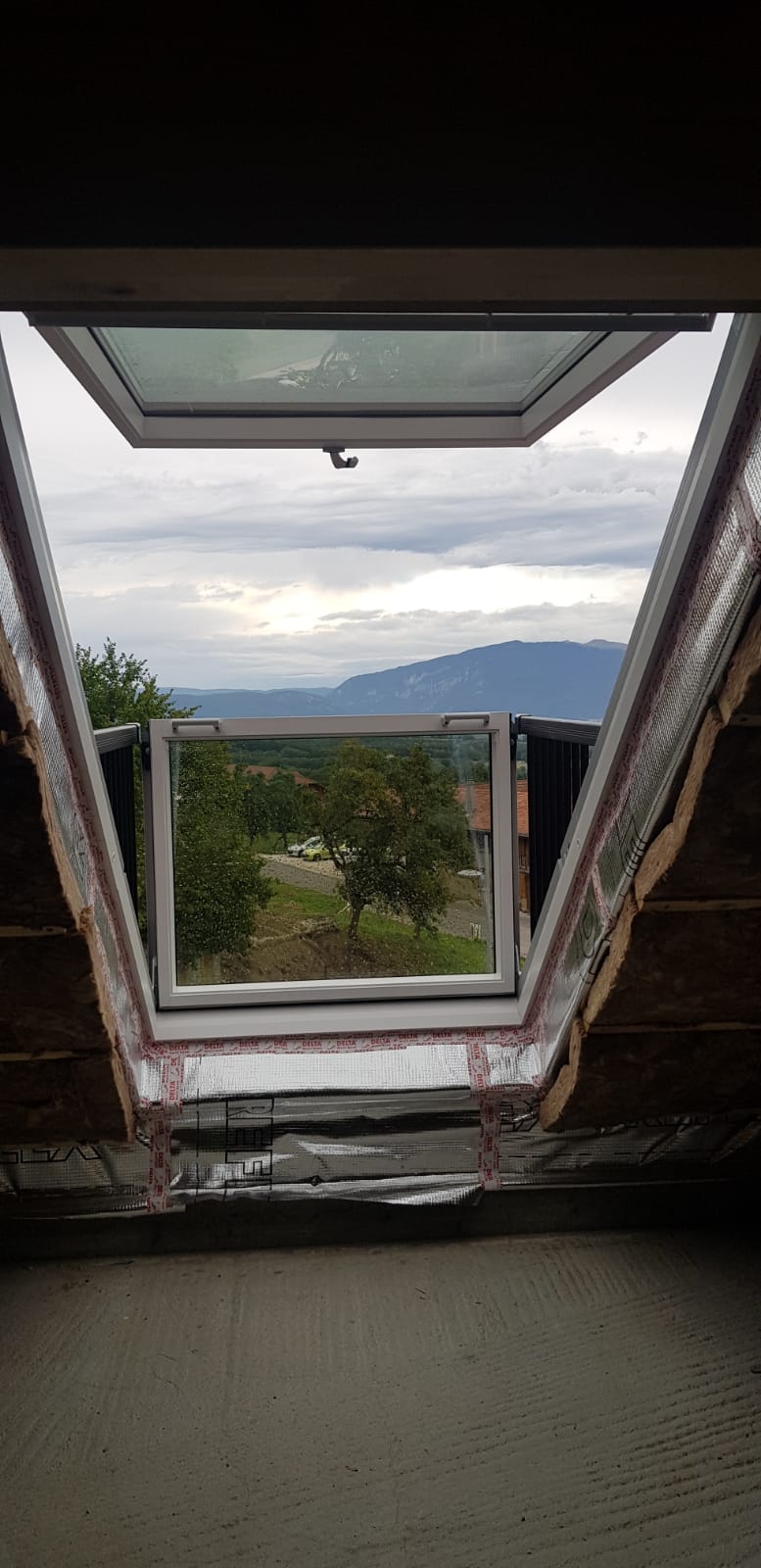 Une vue d'un paysage à travers une lucarne dans une maison.