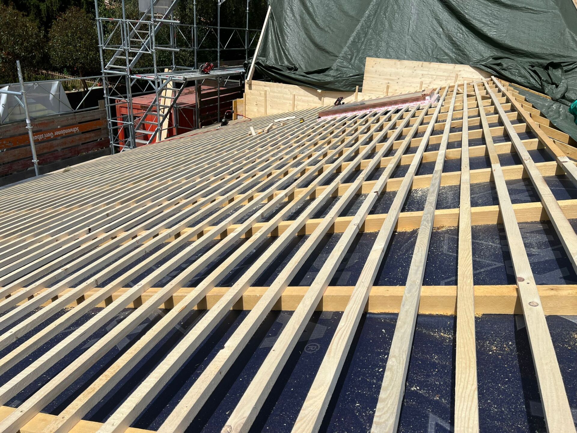 Un toit en construction avec beaucoup de poutres en bois