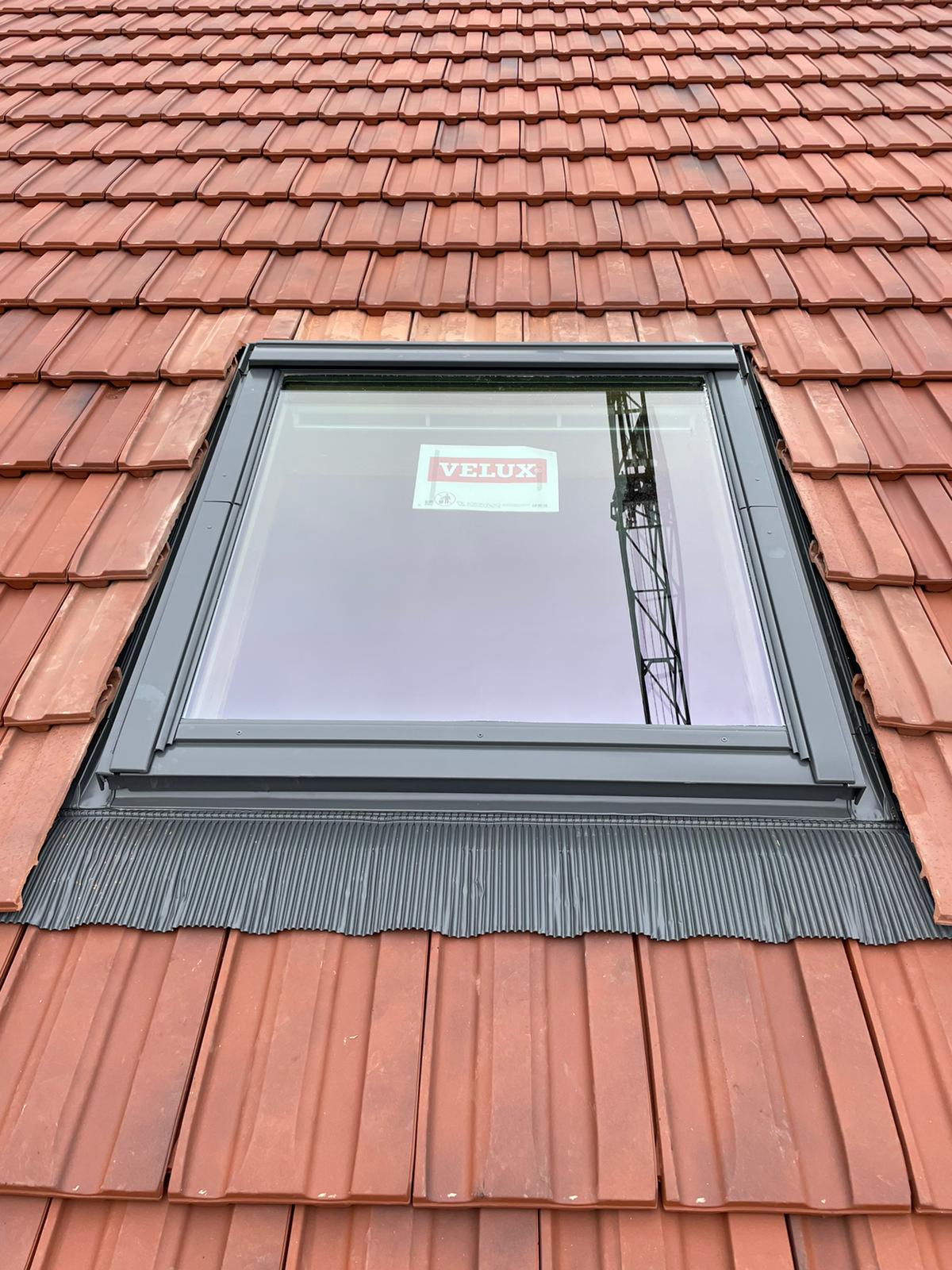 Il y a une lucarne sur le toit d'une maison.
