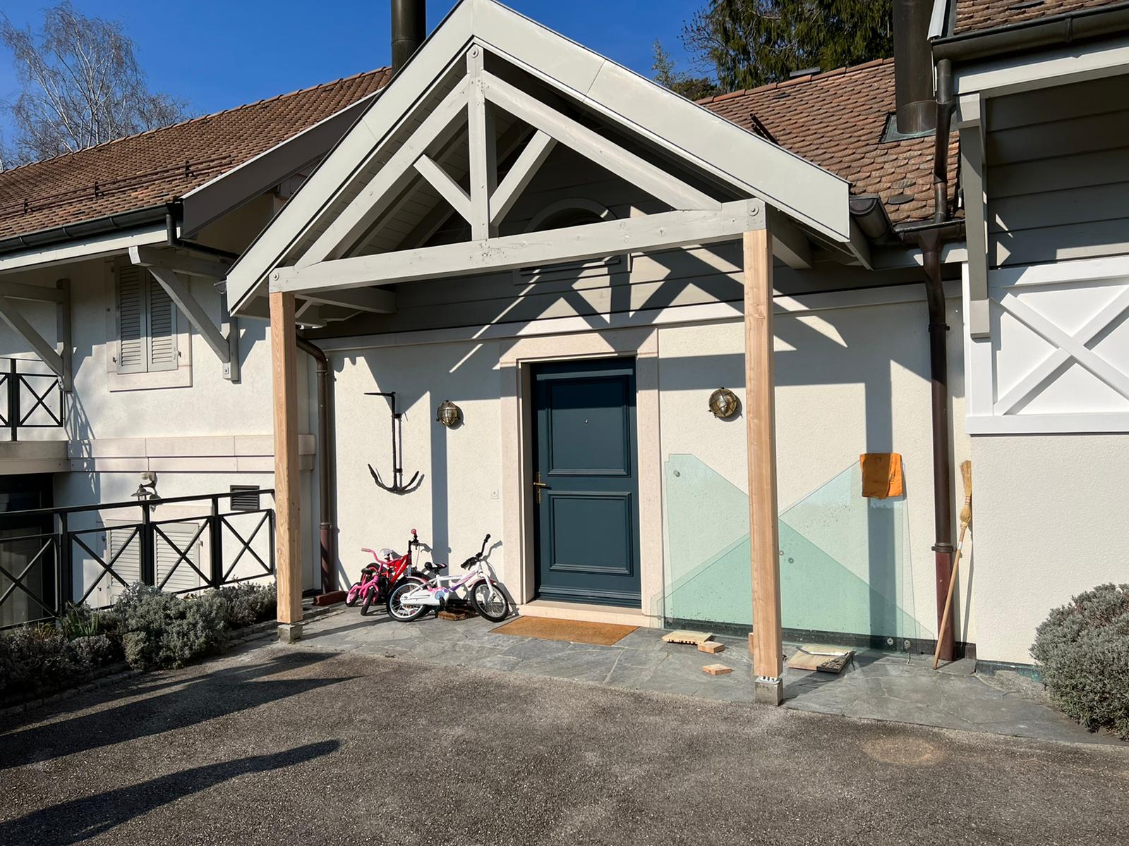 Une maison avec un porche et une porte bleue