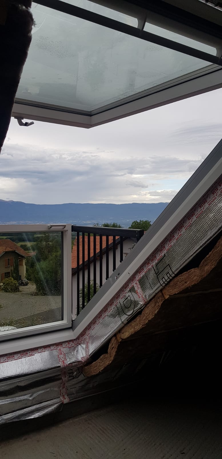 Une fenêtre avec vue sur un balcon et les montagnes.