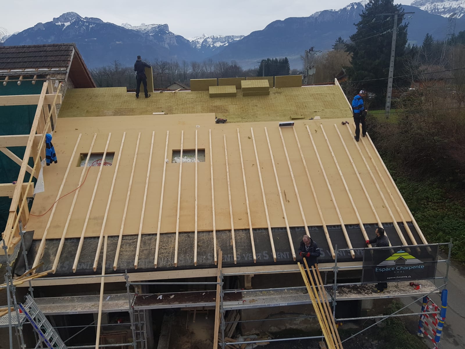 Un groupe de personnes travaille sur le toit d'un bâtiment.