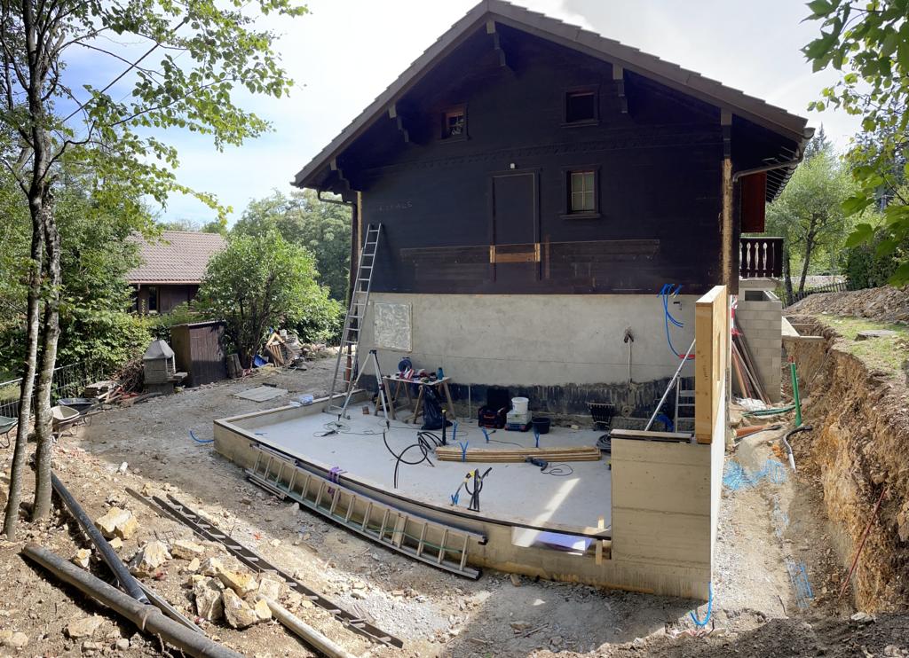 Une maison est en construction au milieu d'un champ de terre