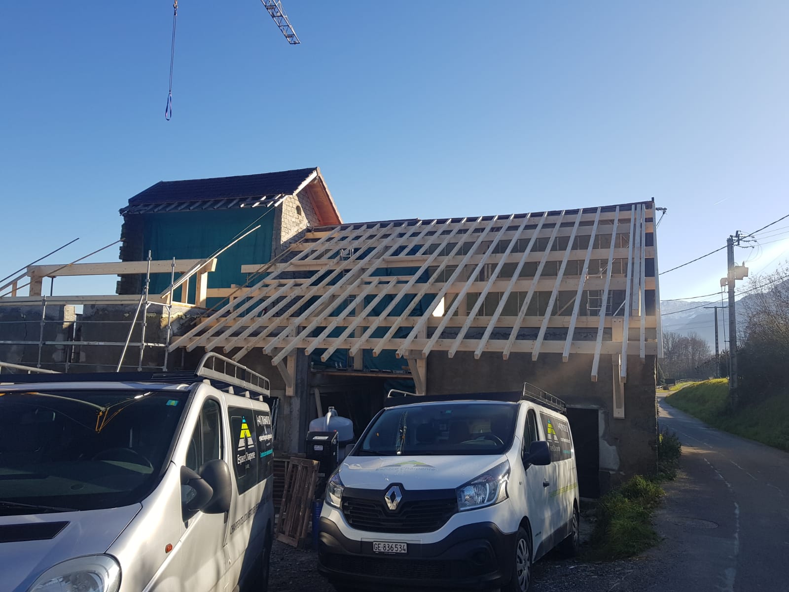 Deux camionnettes sont garées devant un immeuble en construction.