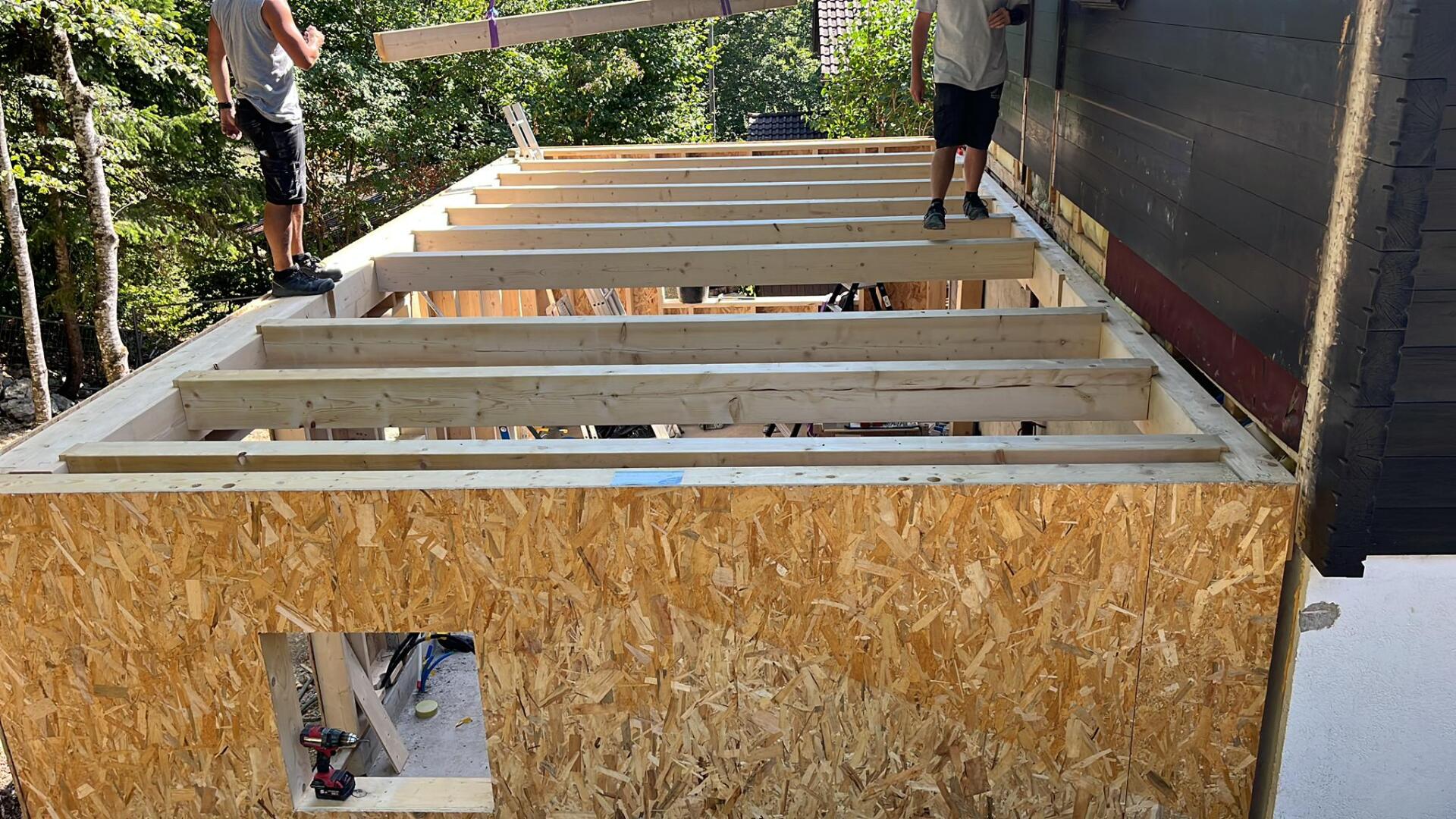 Un couple d'hommes se tient debout au sommet d'une structure en bois.