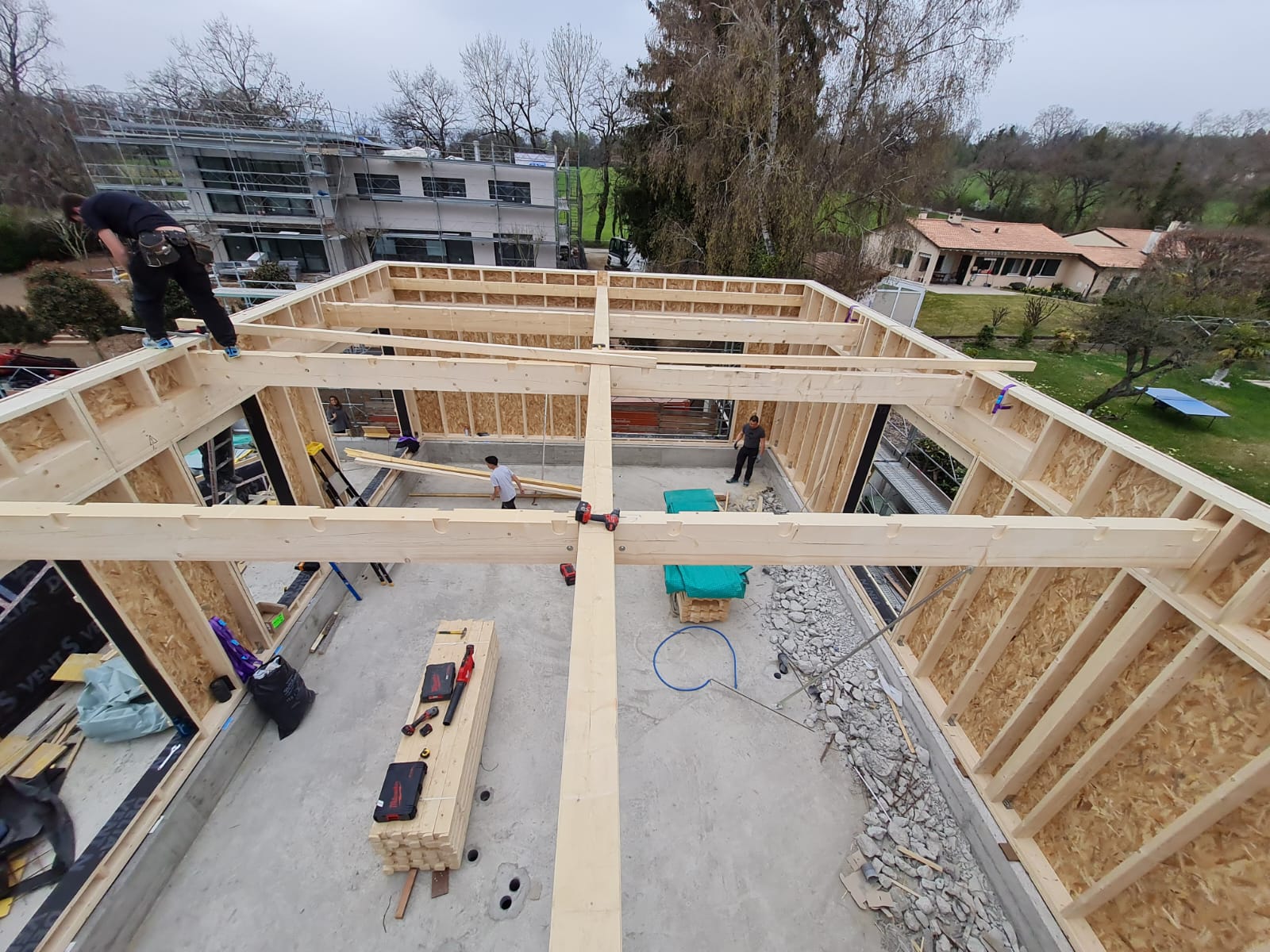 Un homme se tient debout au sommet d'une structure en bois.