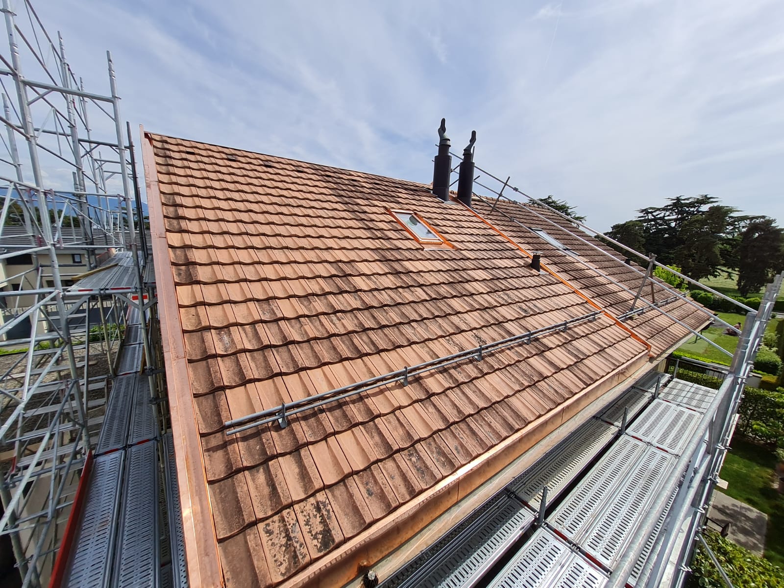 Un toit avec une gouttière en cuivre est en cours de construction sur une maison.