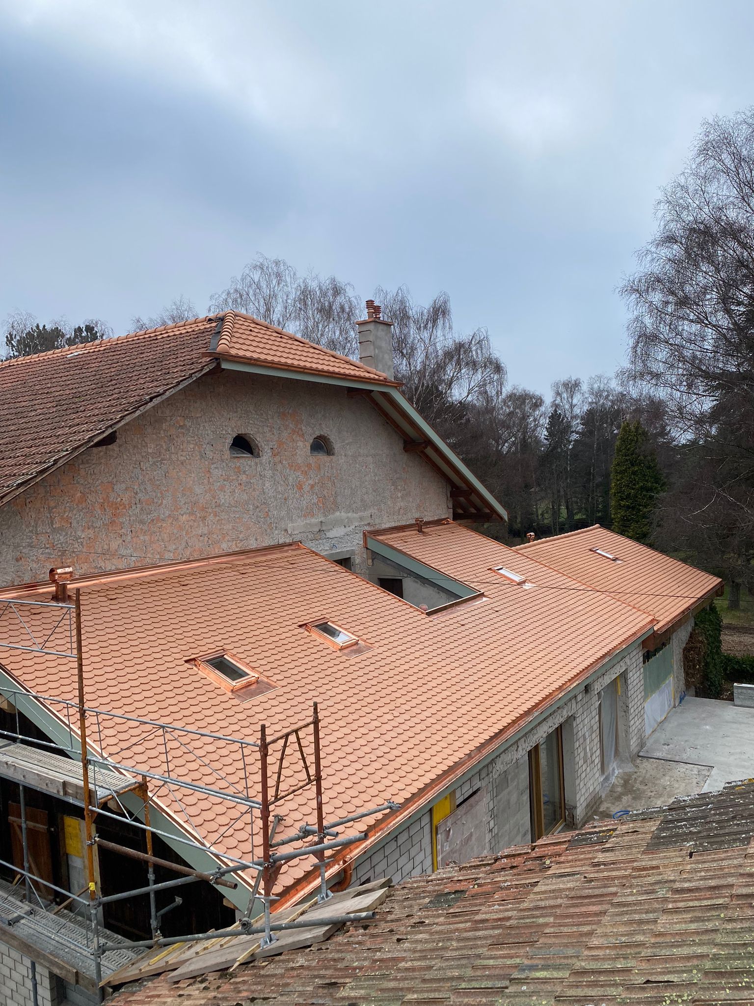 Une maison avec un toit en tuiles est en construction.