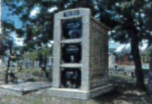 A telephone booth is sitting in the middle of a cemetery.