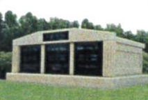 A large stone building is sitting in the middle of a grassy field.