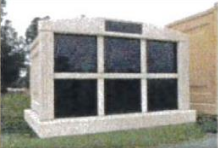 A large building with a lot of windows is sitting in the grass.