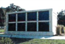 A large building with a lot of windows is sitting in the middle of a field.