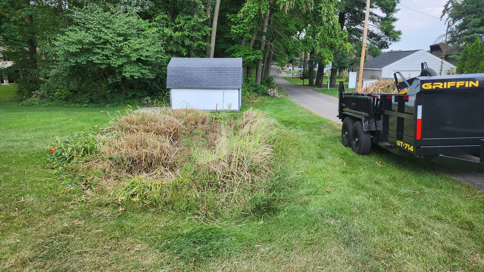 A large pile of grass is sitting on top of a lush green hillside.