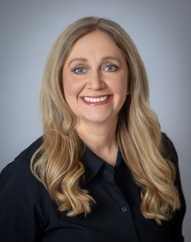 A woman in a black shirt is smiling for the camera.