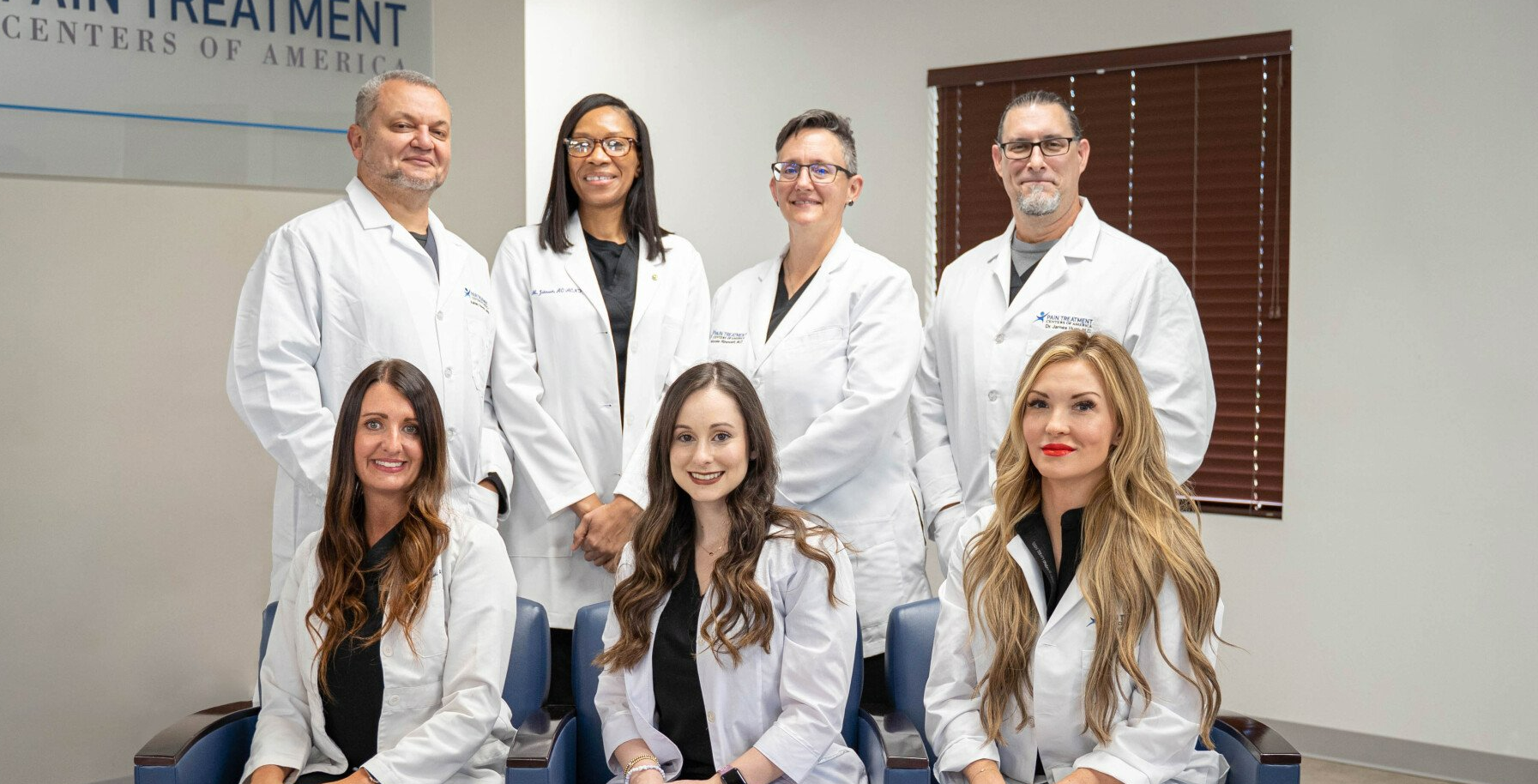 A group of doctors and nurses are posing for a picture.
