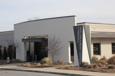 A large white building with a sign in front of it that says pain treatment center of america.