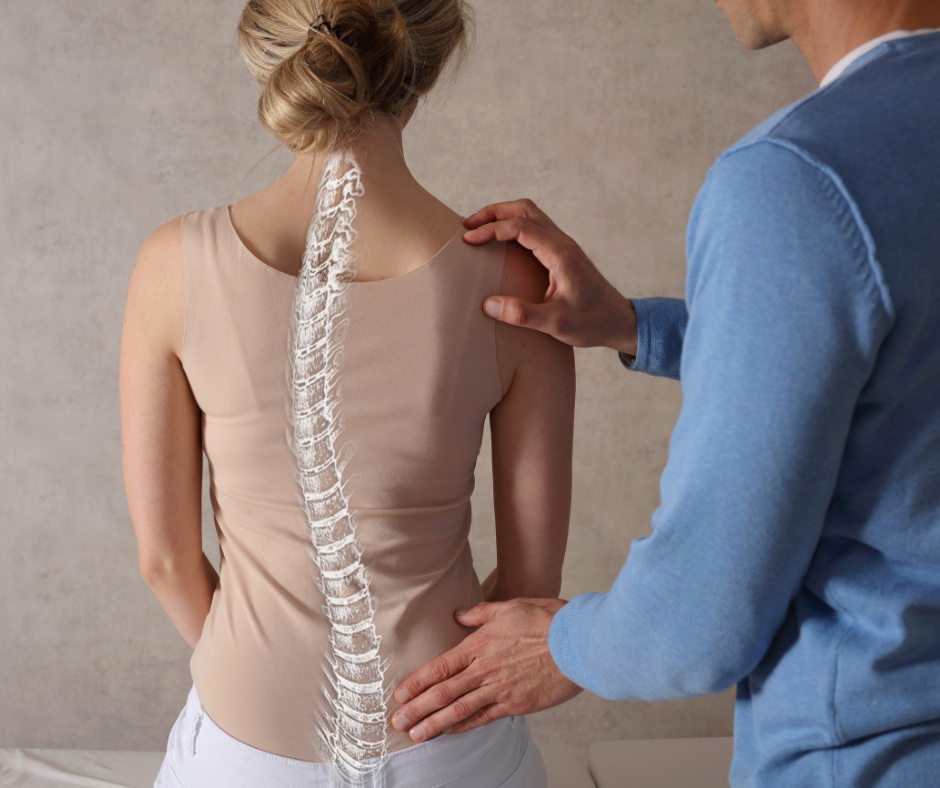 A man is examining a woman 's back with a model of the spine.