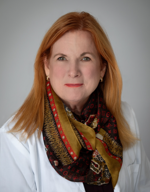 A woman with red hair wearing a scarf and earrings