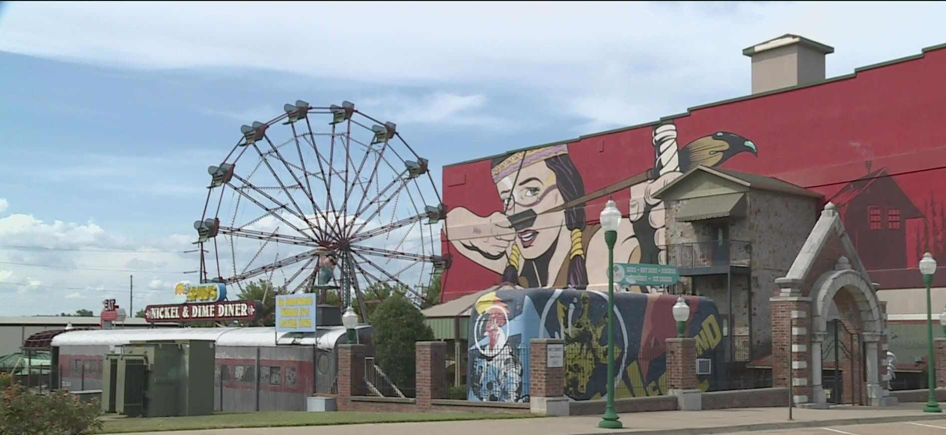 A large red building with a ferris wheel in front of it.