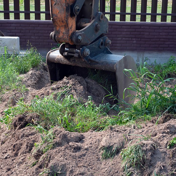 A bulldozer is digging a hole in the dirt in a field.