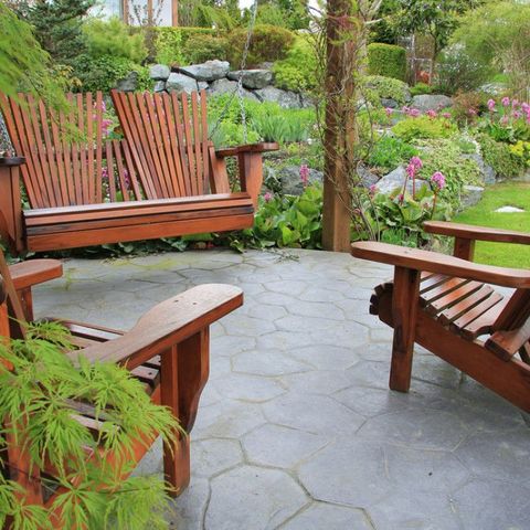 Two wooden chairs and a wooden bench on a patio