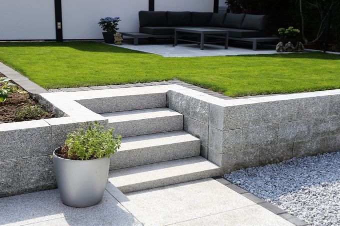 A potted plant sits next to a set of stairs in a garden