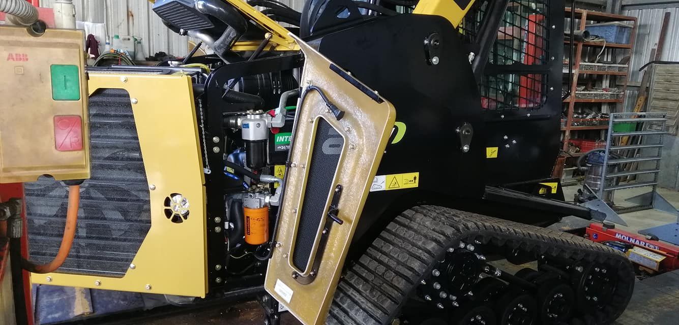 A Yellow and Black Tractor is Parked in a Garage — Giger Machinery Services in Bentley Park, QLD