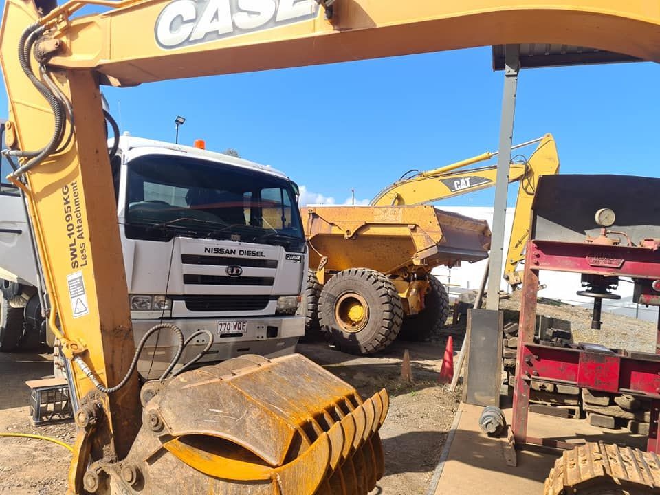 A Case Excavator is Parked Next to a Dump Truck — Giger Machinery Services in Bentley Park, QLD