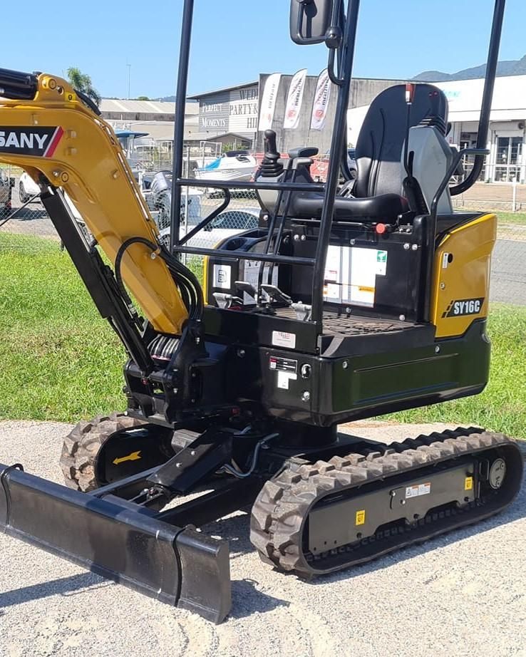 A Small Yellow and Black Excavator is Parked on the Side of the Road — Giger Machinery Services in Bentley Park, QLD