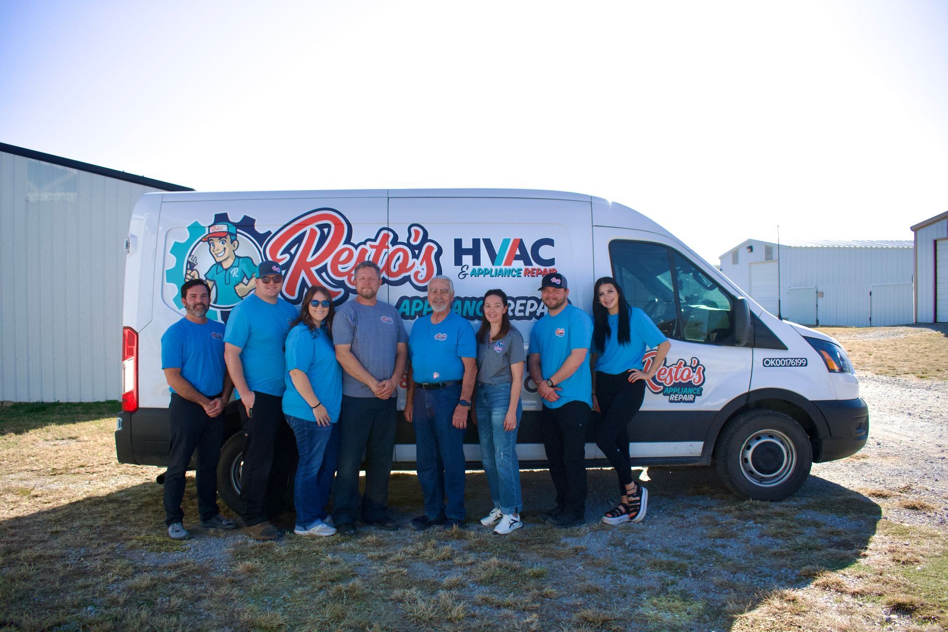 HVAC service team posing beside a branded white van outdoors on a sunny day