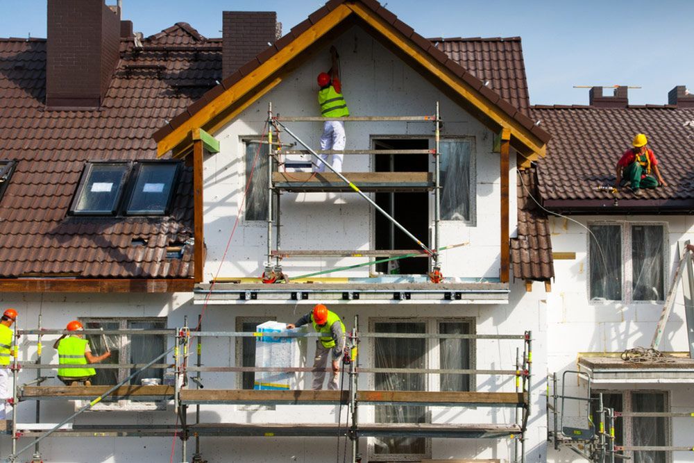 Professional painters painting the outside of a house — House Painting in Fraser Coast, QLD
