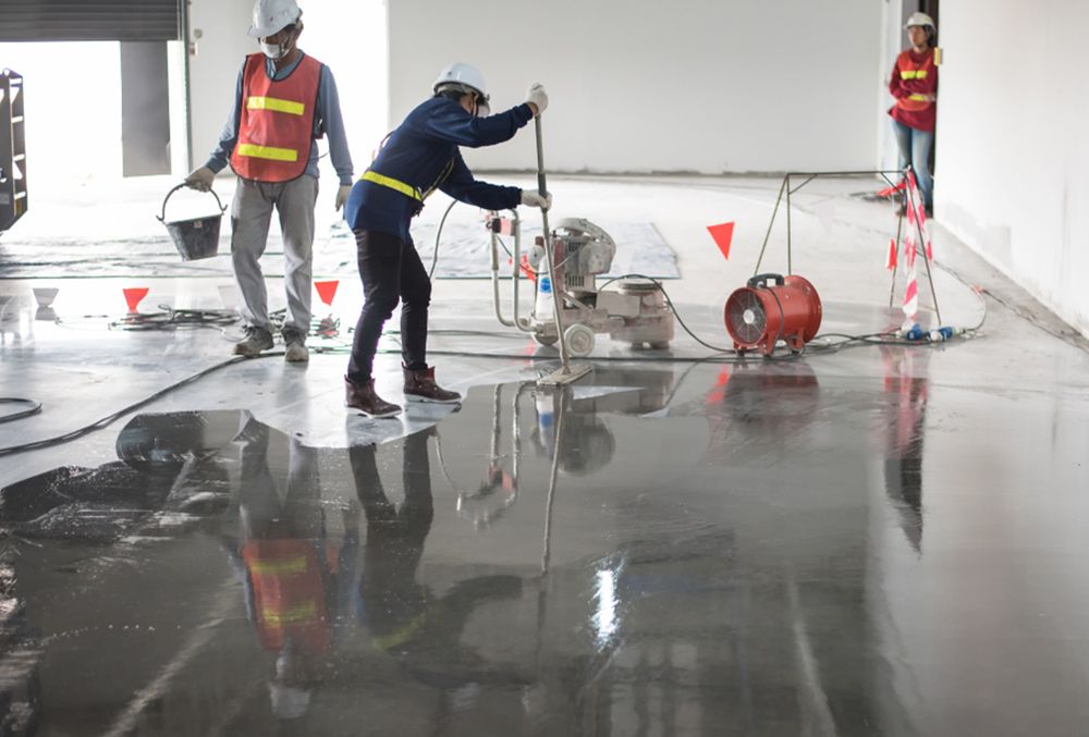 Professional painters using machine to paint the flooring — Painters in Fraser Coast, QLD