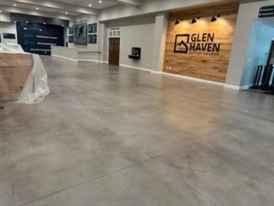 Interior of a Glen Haven sales office, concrete floor, wooden accent wall, and business logo.