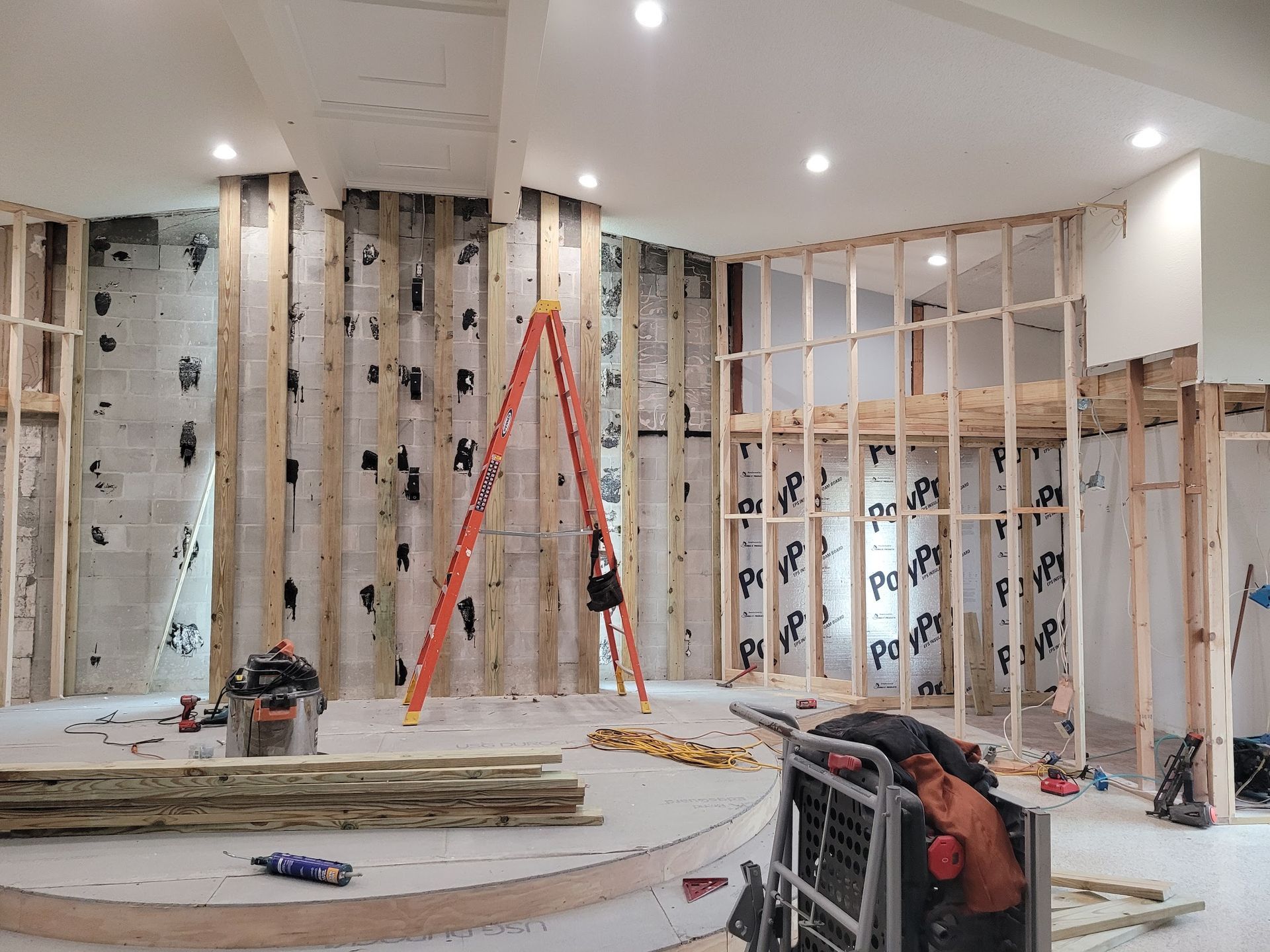 A room under construction with a ladder in the middle of it.