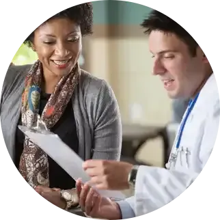 A doctor and a woman are looking at a clipboard.